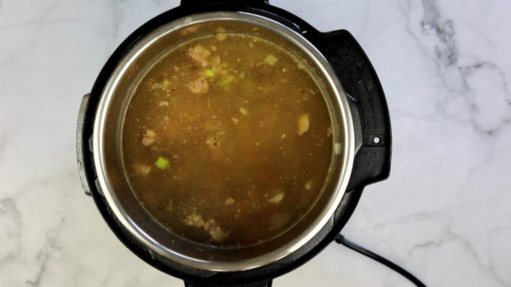 adding broth for homemade beef and barley soup