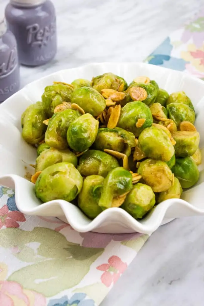 brussels sprouts with almonds and brown butter in a fluted serving bowl