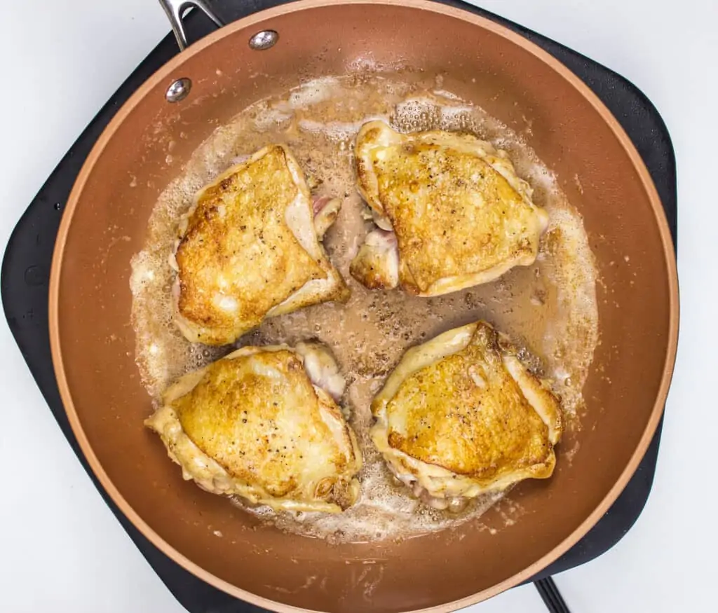 browned chicken thighs in a skillet