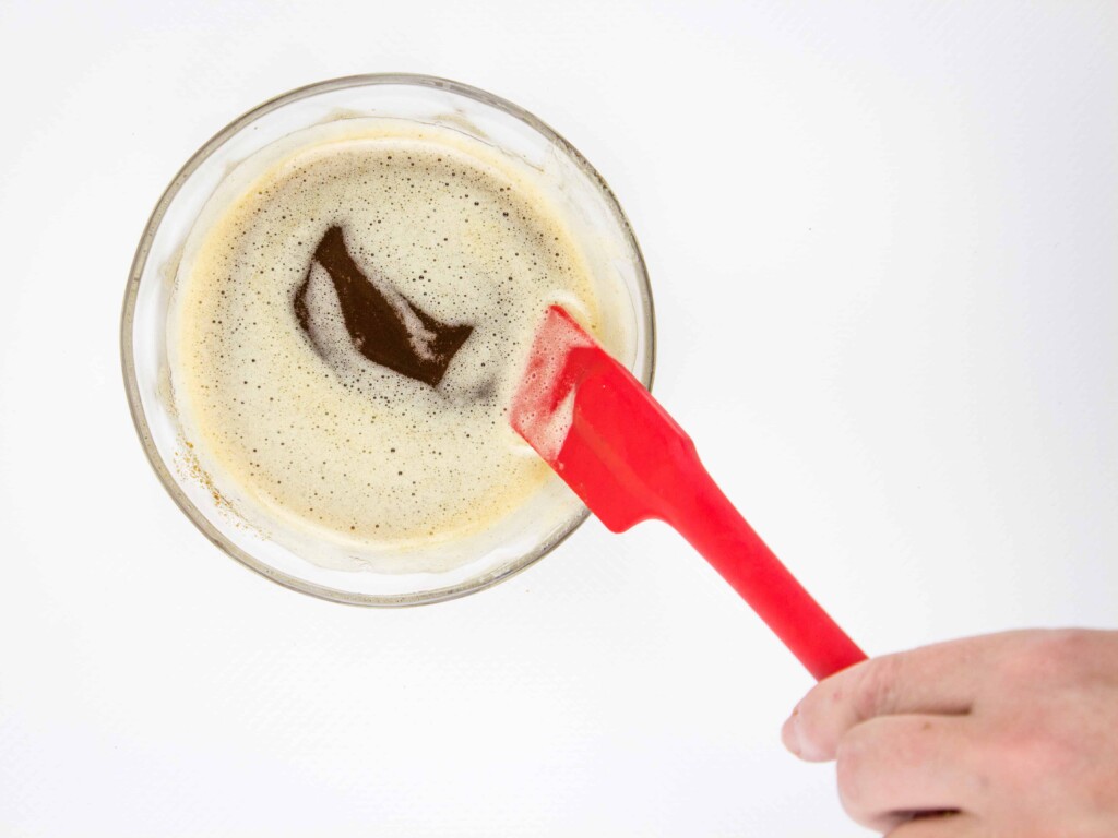 Brown butter in a small glass dish with a red spatula.