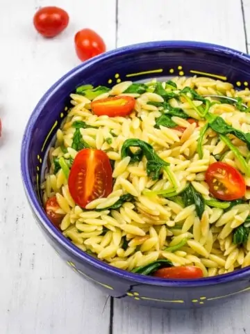 creamy orzo with spinach in a blue serving bowl