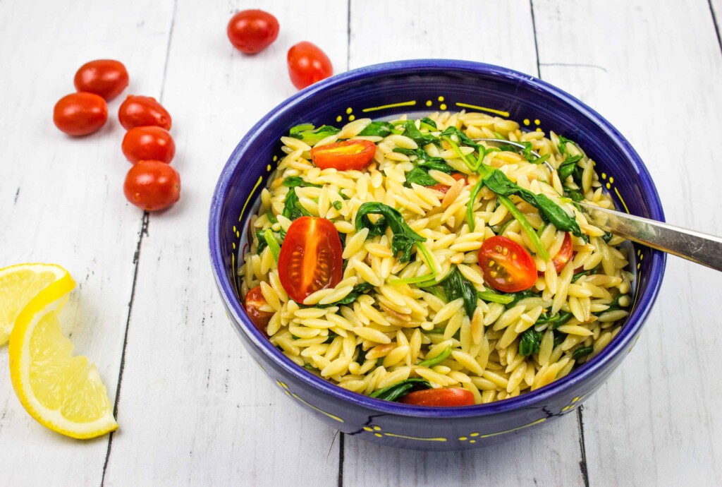orzo with spinach and tomatoes in a serving bowl