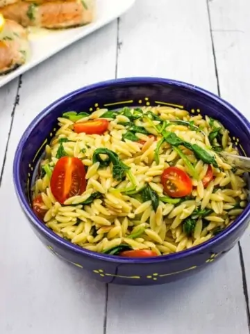 creamy orzo with spinach in a blue serving bowl