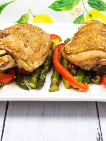 garlic chicken and asparagus on a white plate