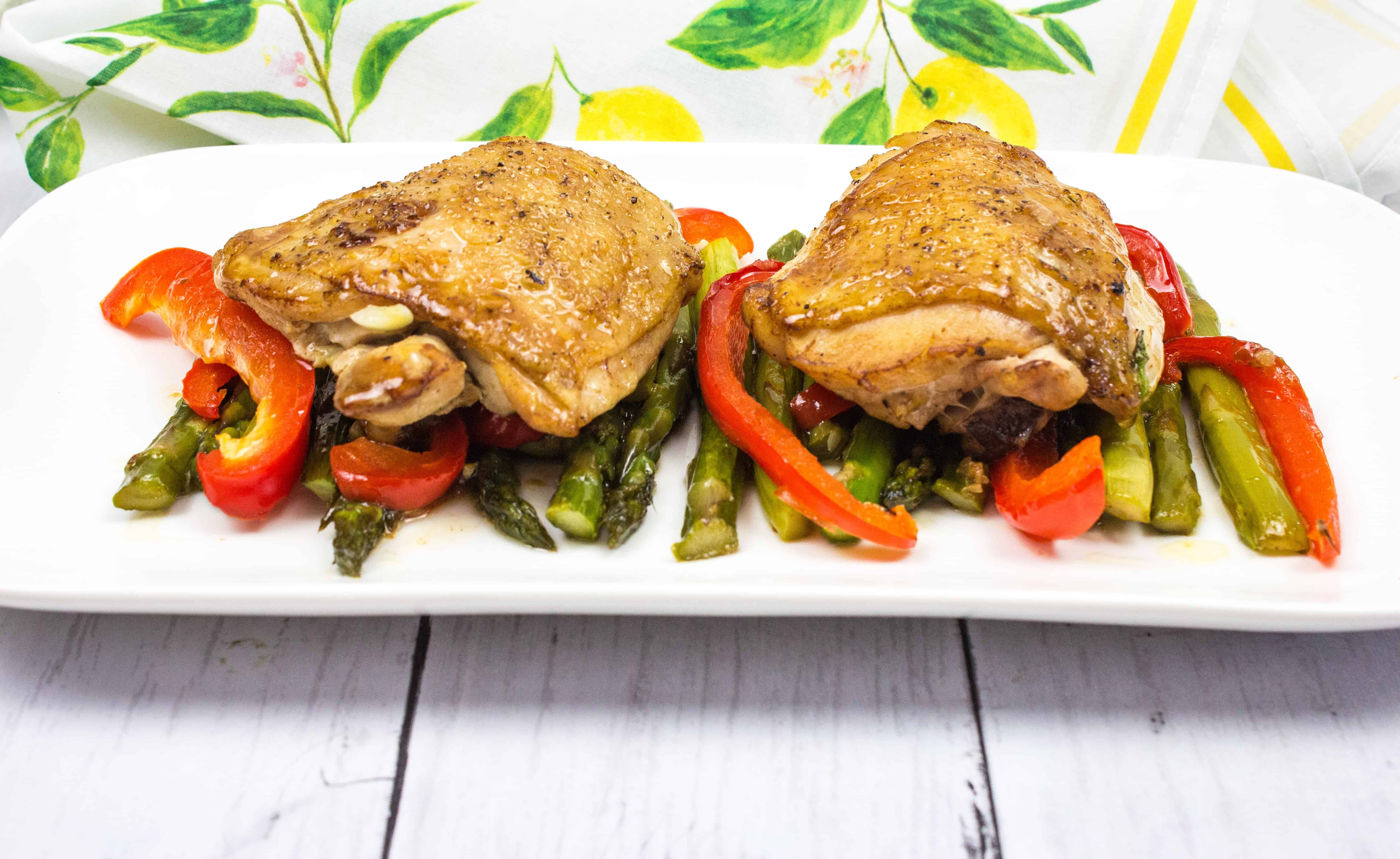 Garlic Chicken Skillet with peppers and asparagus on a white plate.