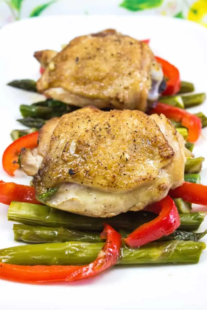 garlic chicken with asparagus on a white platter