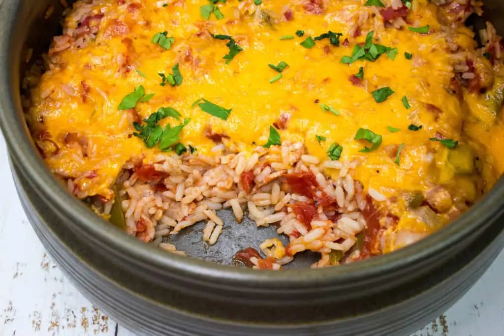 A casserole dish with a closeup of the baked cheesy spanish rice.