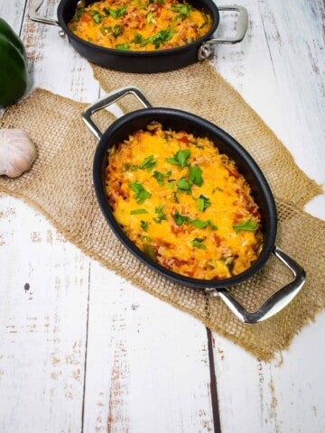 cheesy baked spanish rice in two black serving dishes
