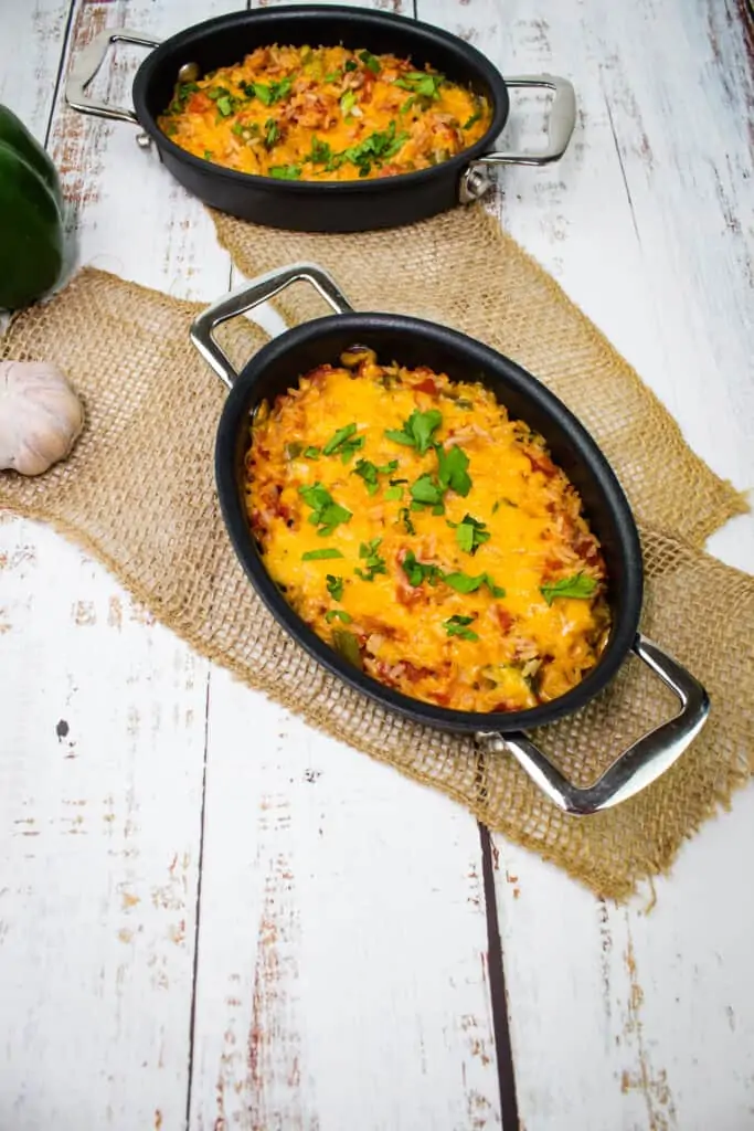 cheesy baked spanish rice in two black serving dishes