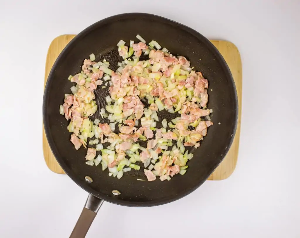 frying the bacon and onions in a skillet 