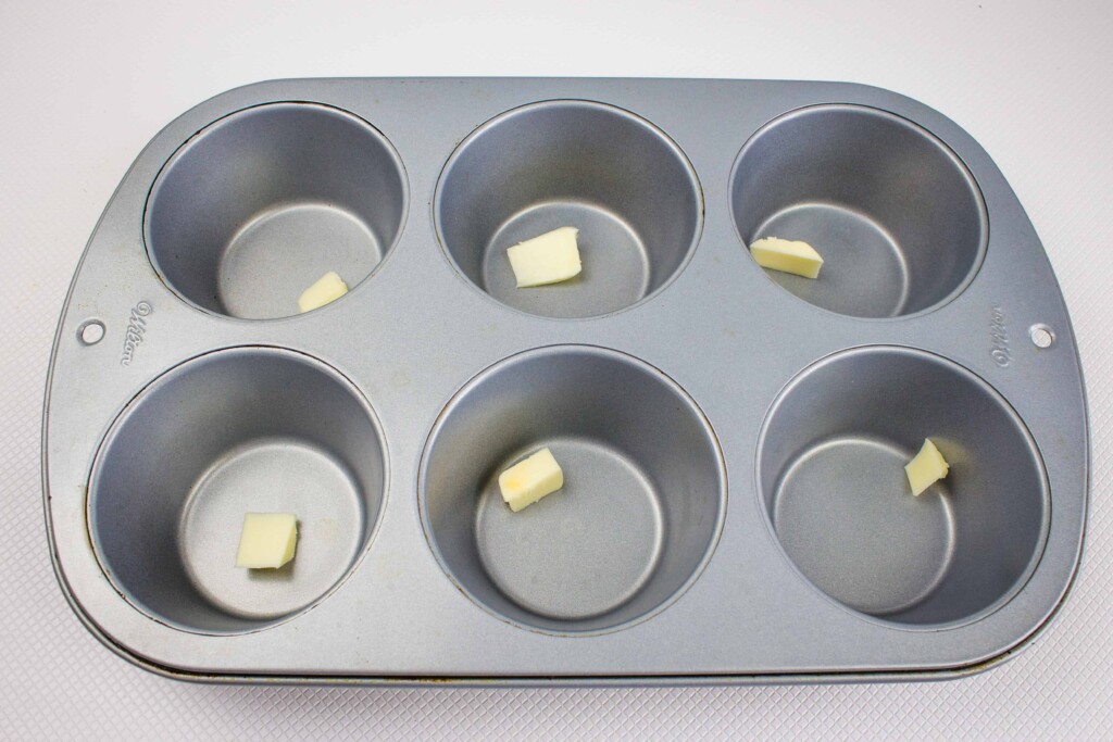 1/2 teaspoon of butter in each of the 6 muffin cups