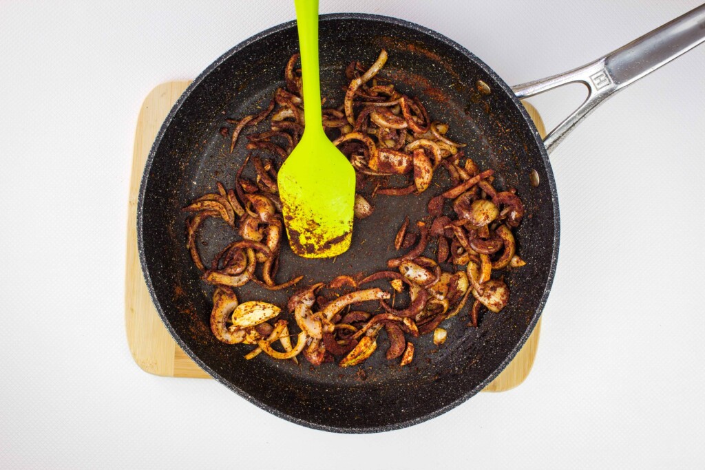 adding the spices to the skillet and cooking them out