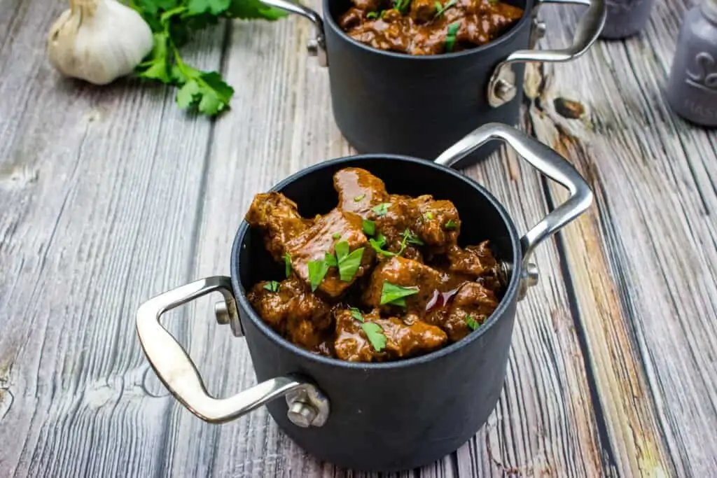 authentic hungarian goulash in an individual size pot with a second in the background