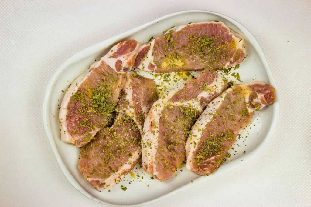 Boneless pork chops seasoned with salt, pepper, garlic powder and tarragon.