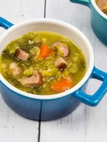 Two bowls of soup on a wooden table.