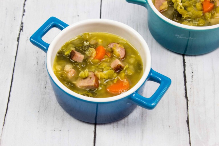 Two bowls of soup on a wooden table.