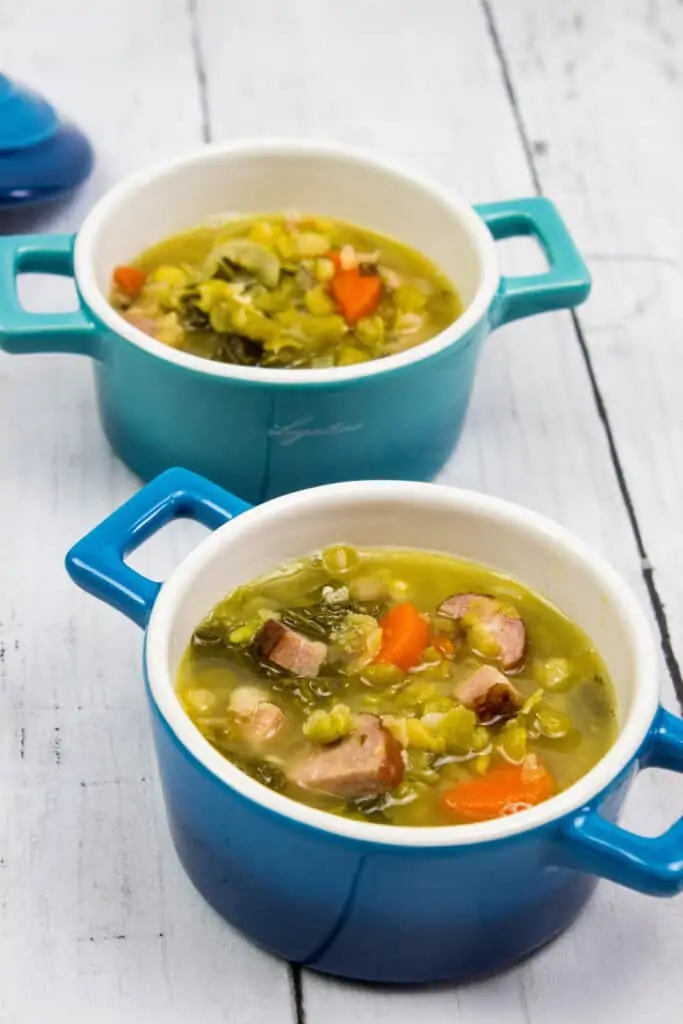 split pea soup with ham and sausage in two blue soup bowls