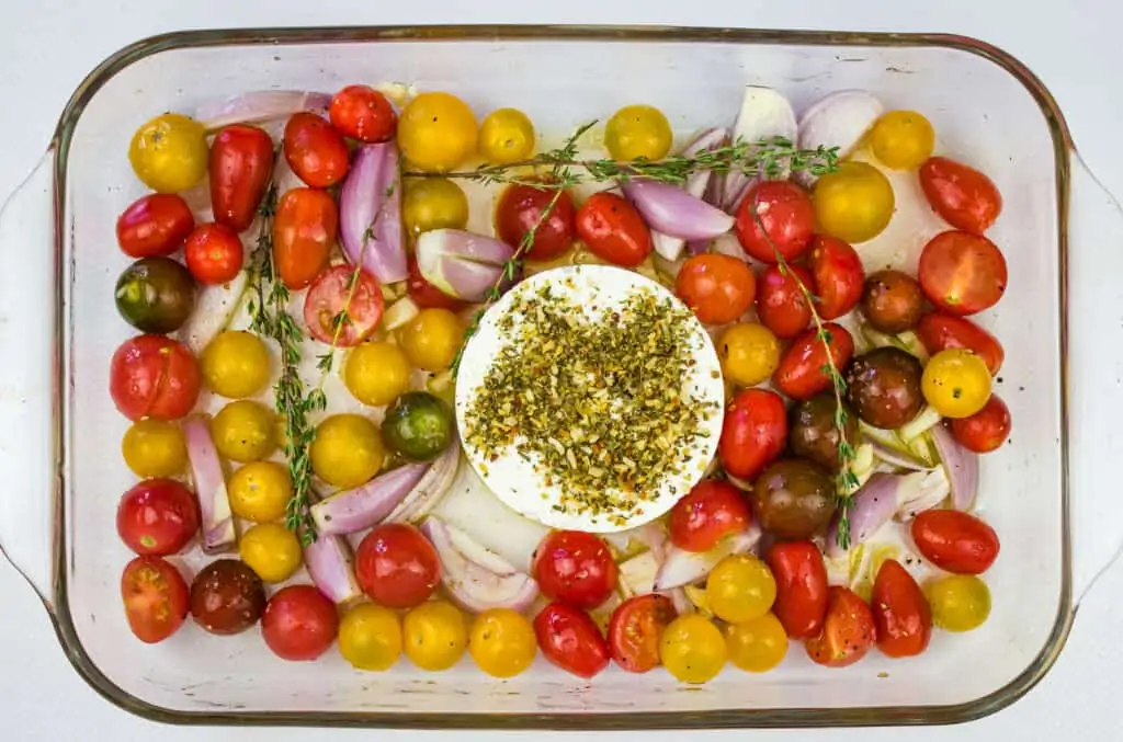 tomatoes, garlic, shallot and block of feta in a baking dish to make baked feta pasta