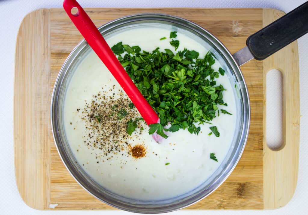 Parsley and spices added to the cheesy cream sauce.