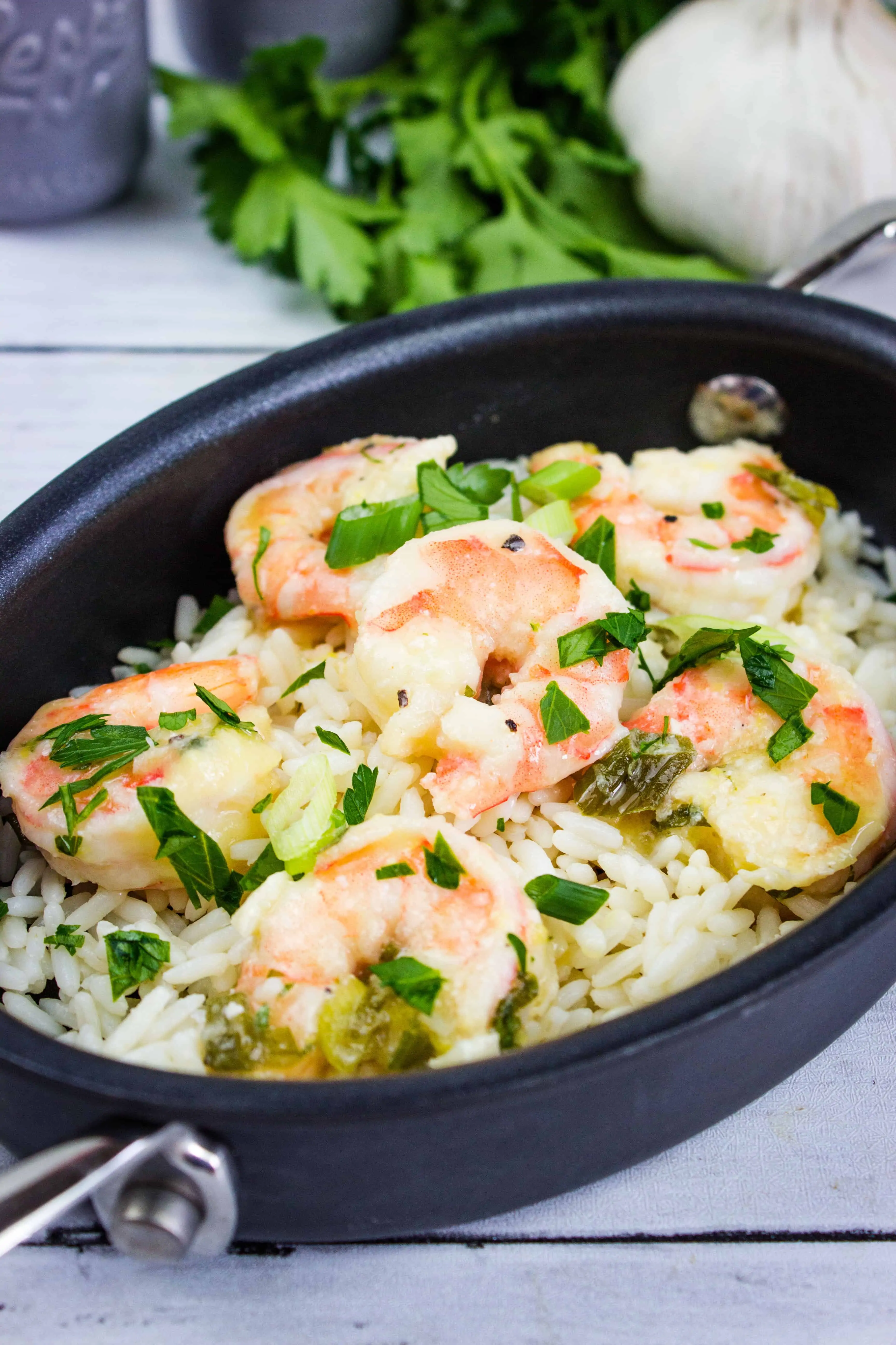 a closeup of shrimp scampi in a black oval serving dish
