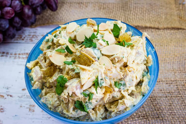 Curried chicken salad with raisins in a serving bowl.