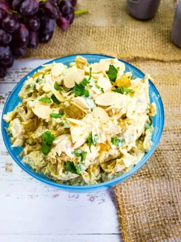 curry chicken salad with grapes in a bloue serving dish