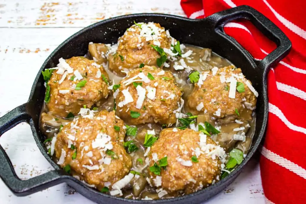 Chicken Marsala Meatballs cooked in a cast iron skillet.