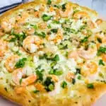 A shrimp scampi pizza loaded with melted cheese.