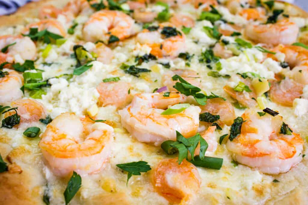 A closeup of shrimp scampi pizza.