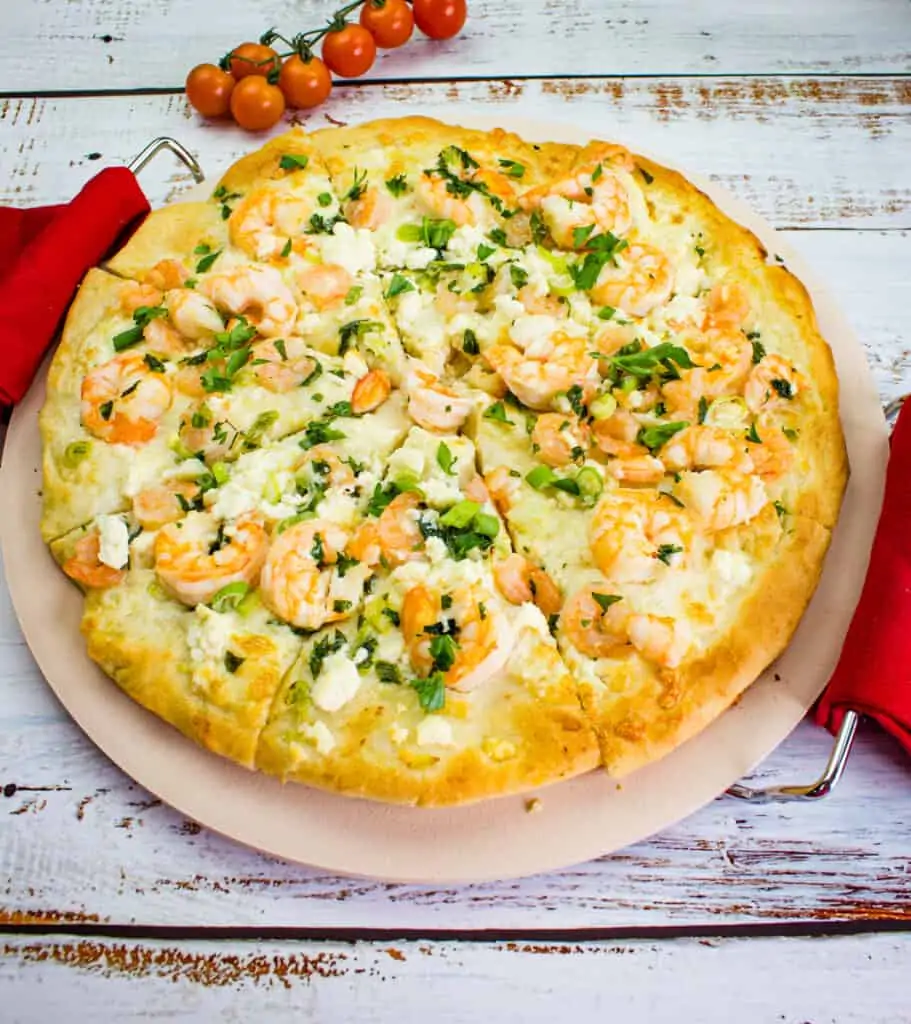 shrimp scampi pizza on a pizza stone