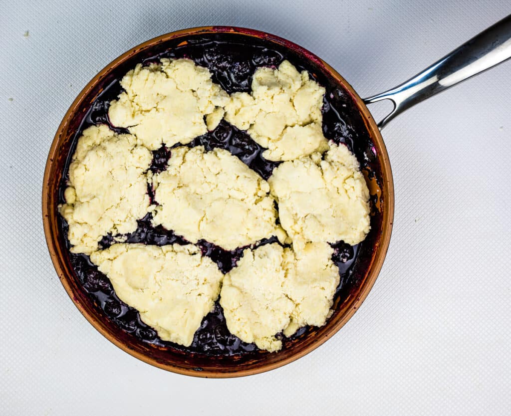 dropping biscuits to the top of blueberry mixture