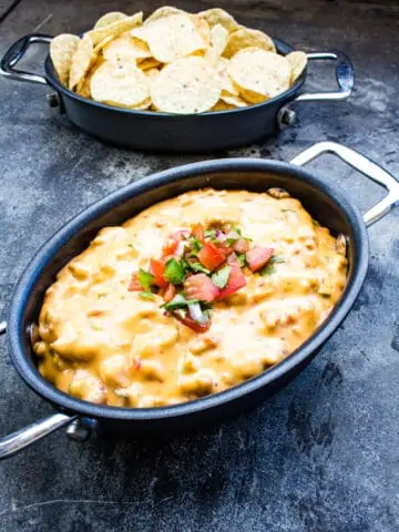 smoked queso in a black dish with chips in the background