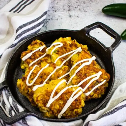 Corn fritters in a black serving dish.