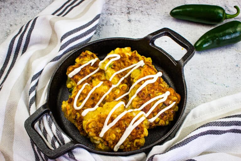 Corn fritters in a black serving dish.