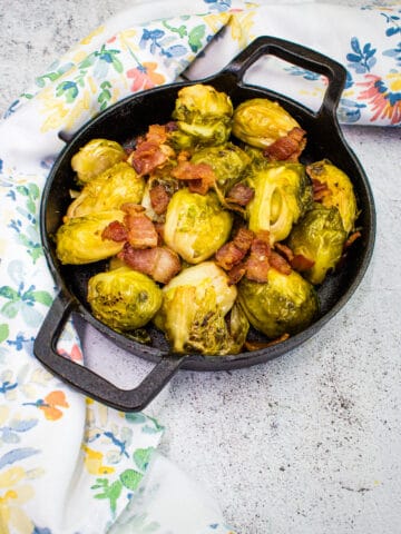 smoked brussels sprouts with bacon in a black dish