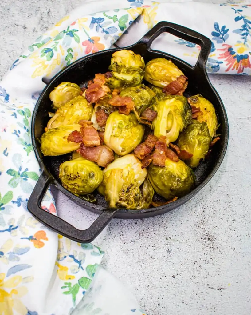 smoked brussels sprouts with bacon in a black dish