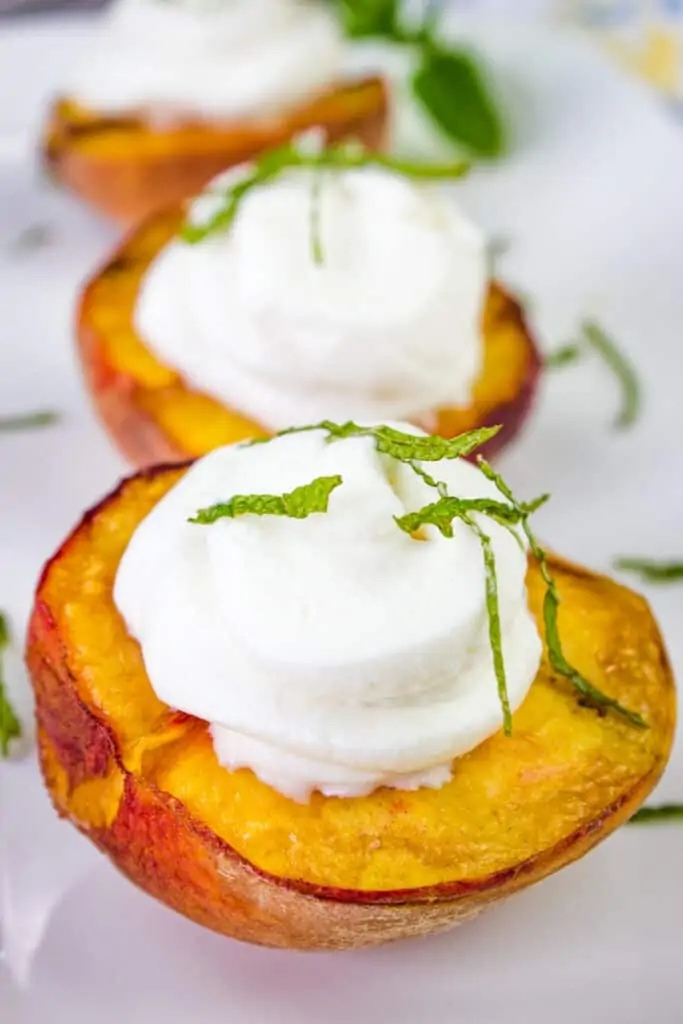 smoked peaches with spiced rum whipped cream on a platter