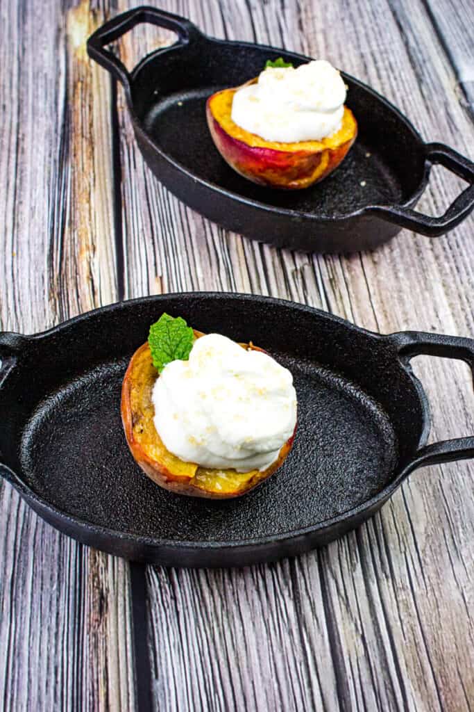 smoked peaches with spiced rum whipped cream in black dishes