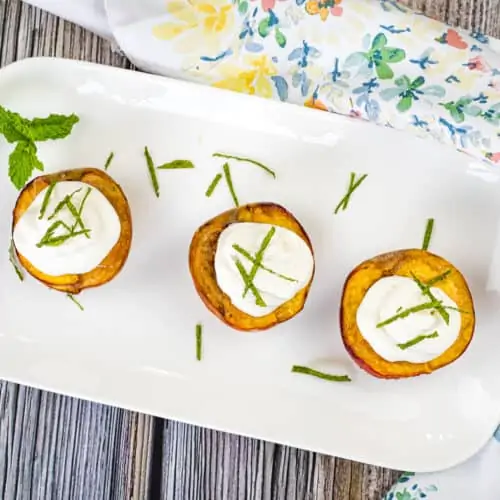 smoked peaches with spice rum whipped cream on a platter