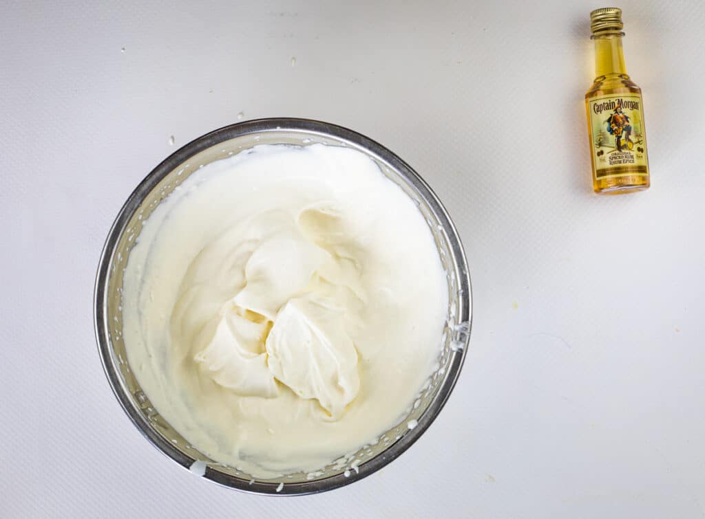 spiced rum whipped cream with stiff peaks in a bowl