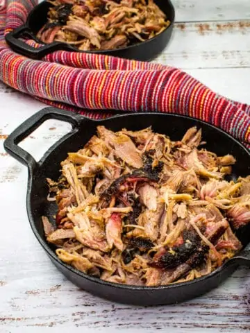 smoked pulled pork in black serving dishes