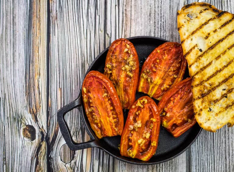 Grilled tomatoes on a wooden table.