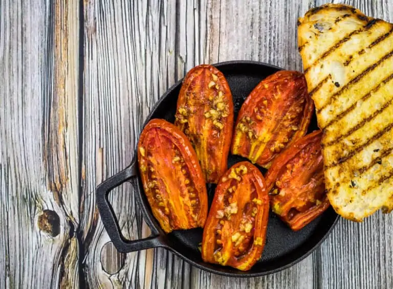 Grilled tomatoes on a wooden table.
