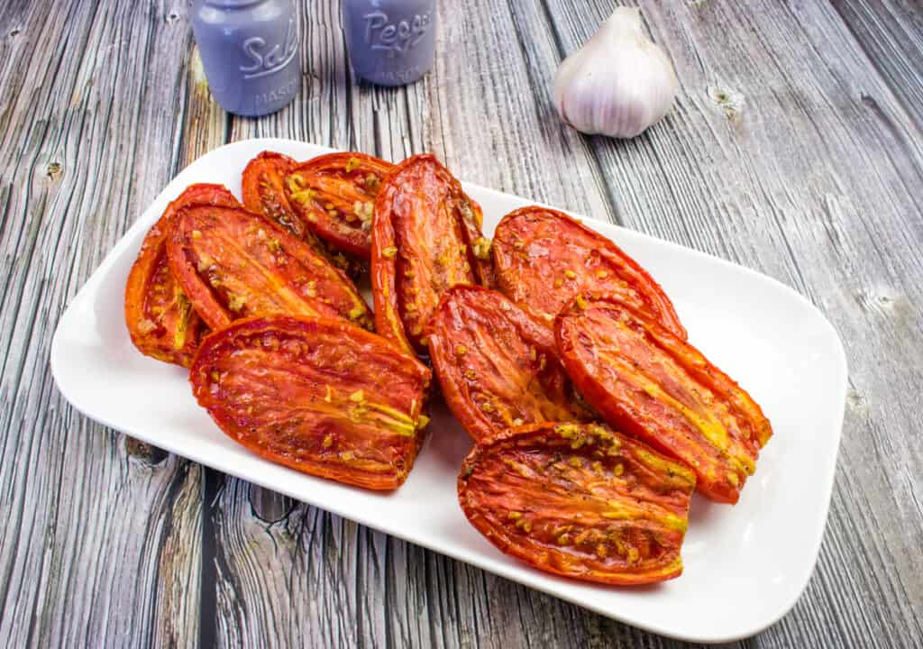 Smoked tomatoes on a white platter.