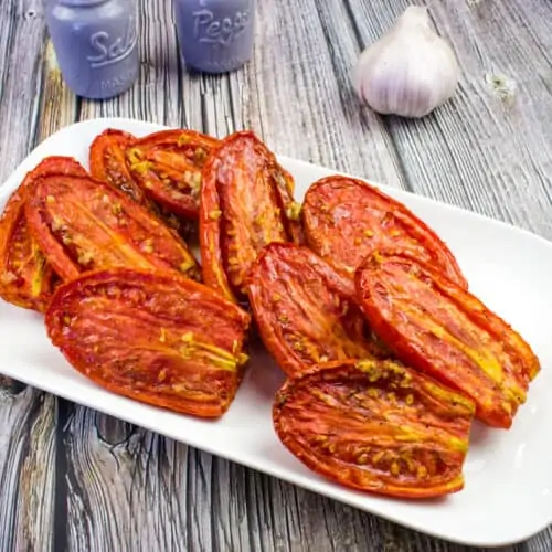 Smoked tomatoes on a white platter.