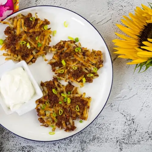 Crispy Corned Beef Fritters on a white plate with Sour Cream