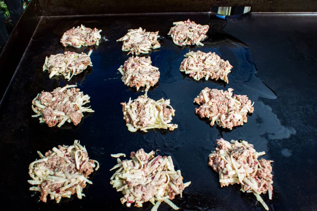 corned beef fritters cooking on blackstone griddle