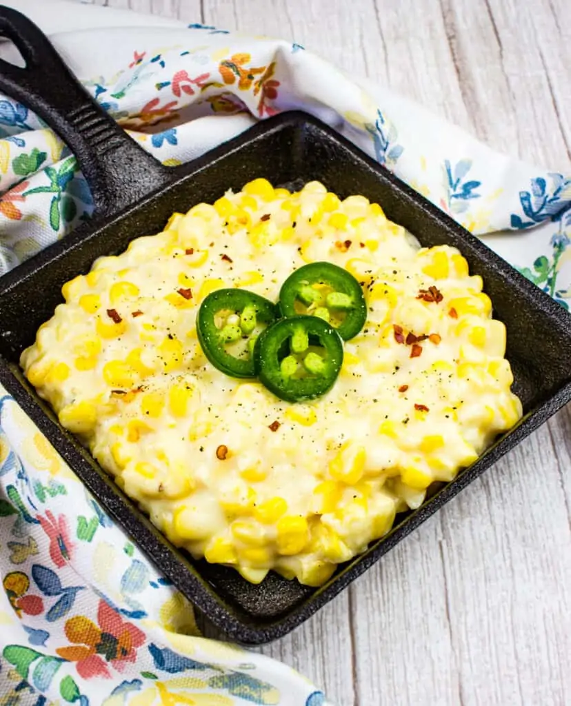 creamed corn in a black serving dish