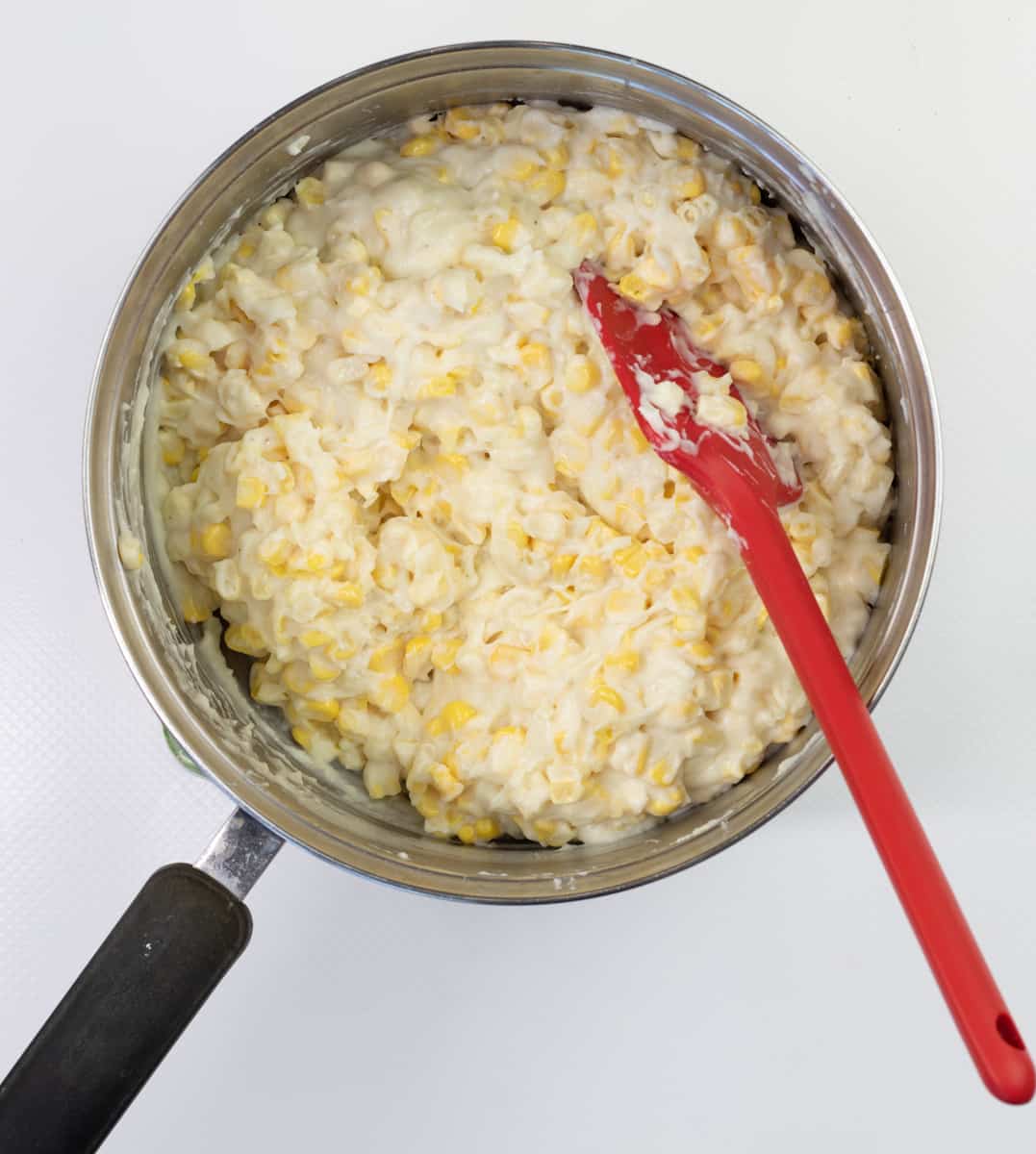 Mixing corn and sauce and heating through