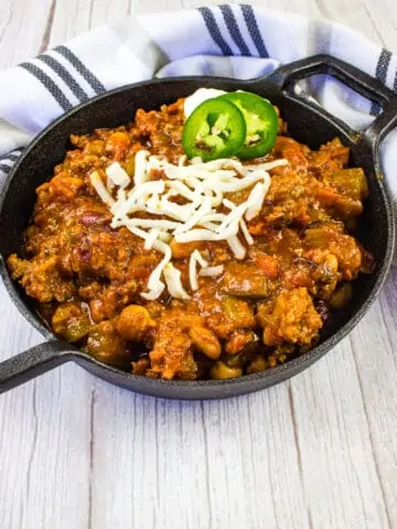 over the top chili in a black serving dish